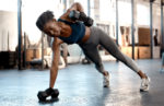 Shot of a sporty young woman exercising with dumbbells in a gym