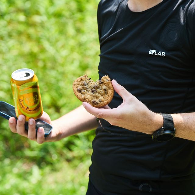 a runner holding a cookie and a seltzer water