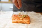 the-author-sprinkles-a-citrus-rub-on-a-filet-of-salmon-to-news-photo-1688043825